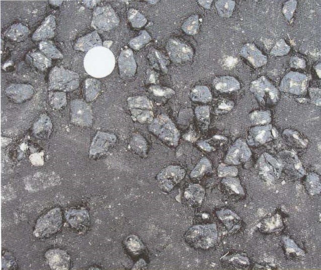 رویه آسفالت گرم کوب چیپ شده (Chipped)، سکه نشان داده‌شده یک یورو به قطر 23 میلی‌متر است